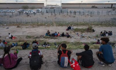 Imigrantes se recuperam às margens do Rio Grande, na divisa entre Estados Unidos e México, em Ciudad Juarez (Justin Hamel/Bloomberg)