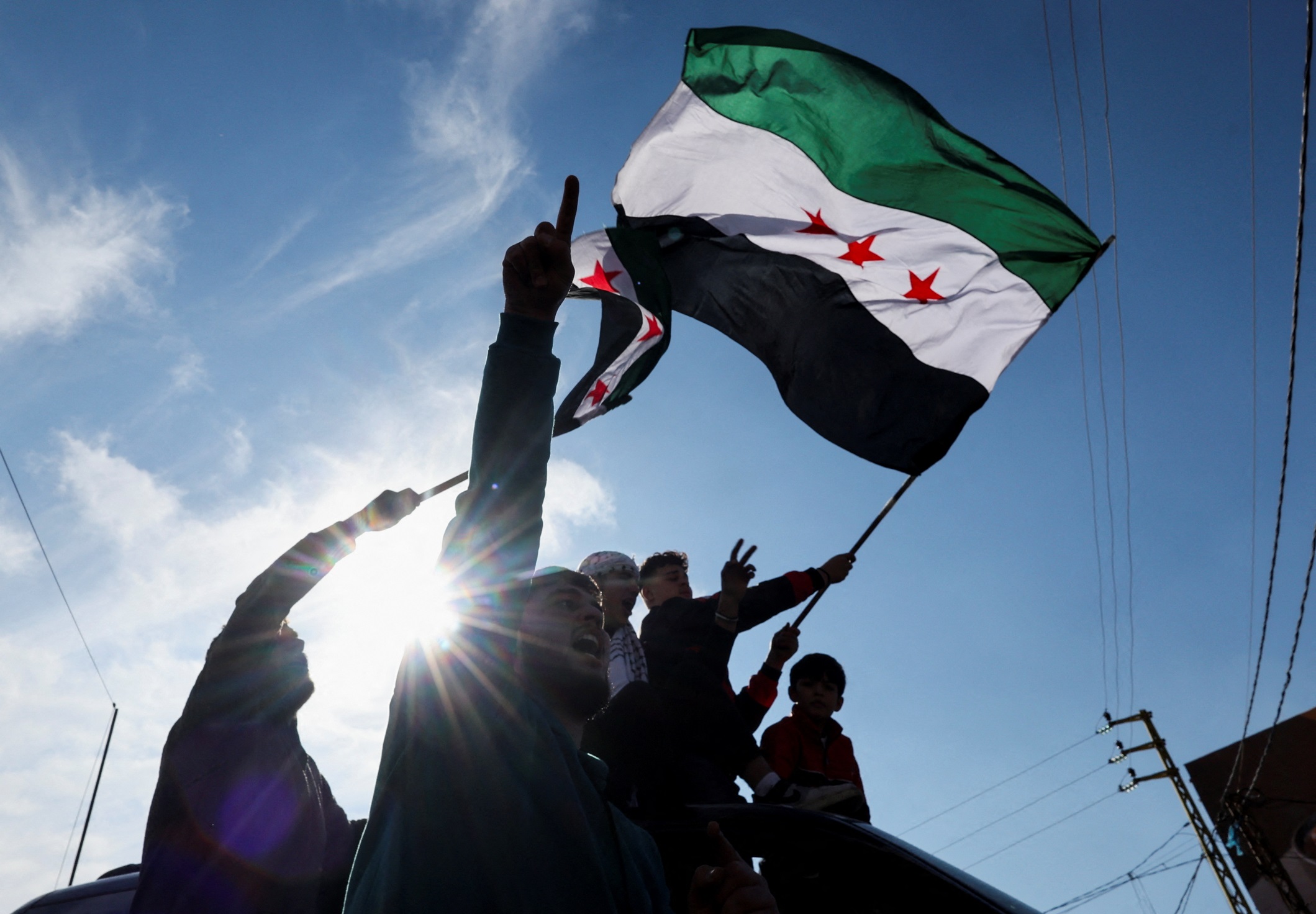 People make their way as they attempt to cross into Syria after Syrian rebels announced that they have ousted President Bashar al-Assad, near Masnaa Border Crossing