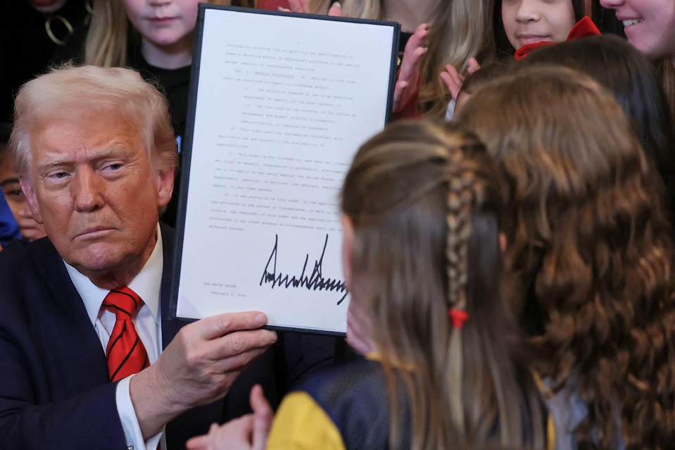 Donald Trump segurando a ordem executiva signada.