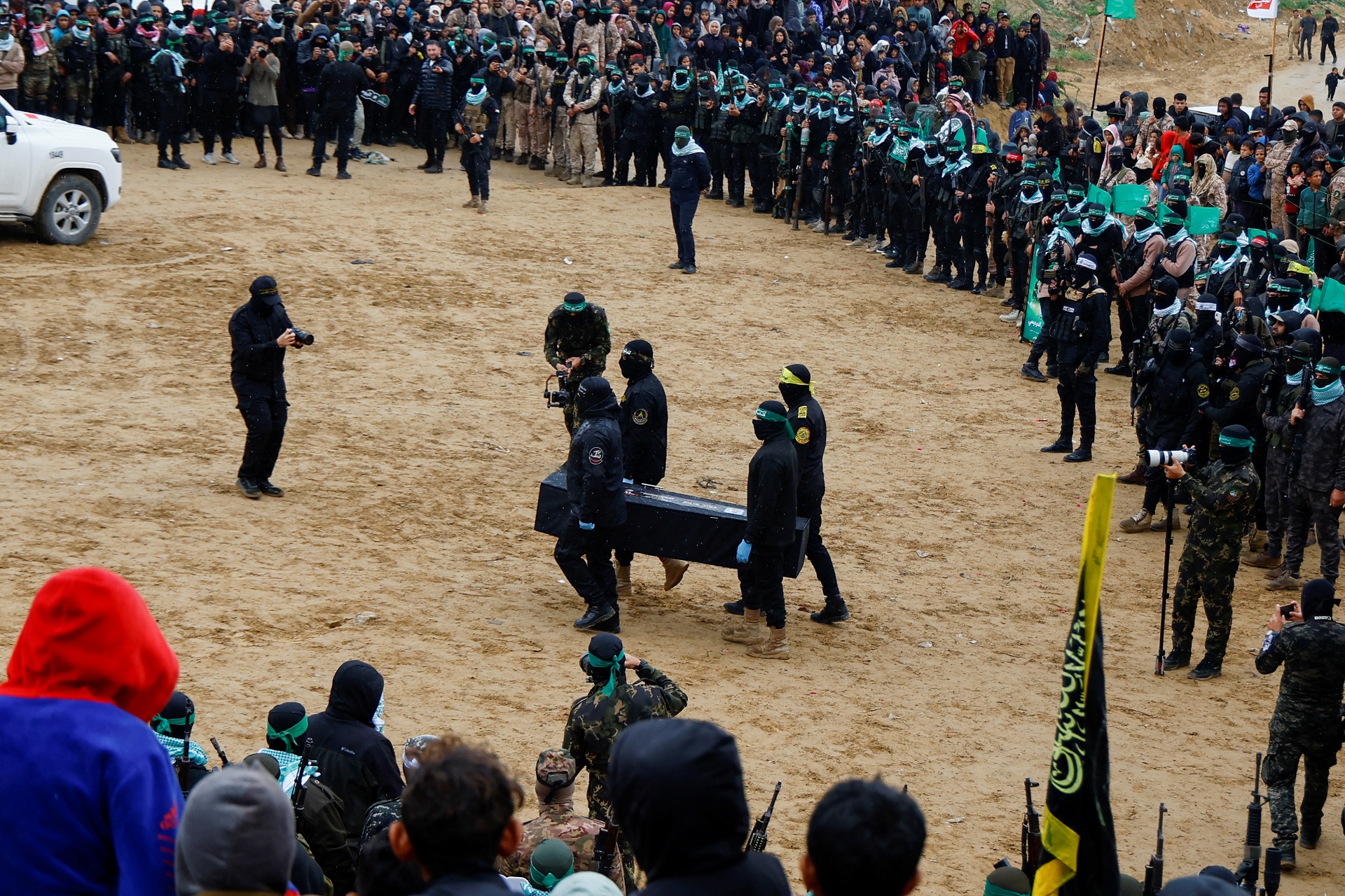 Militantes palestinos em um funerário carregando o caixão dos reféns.