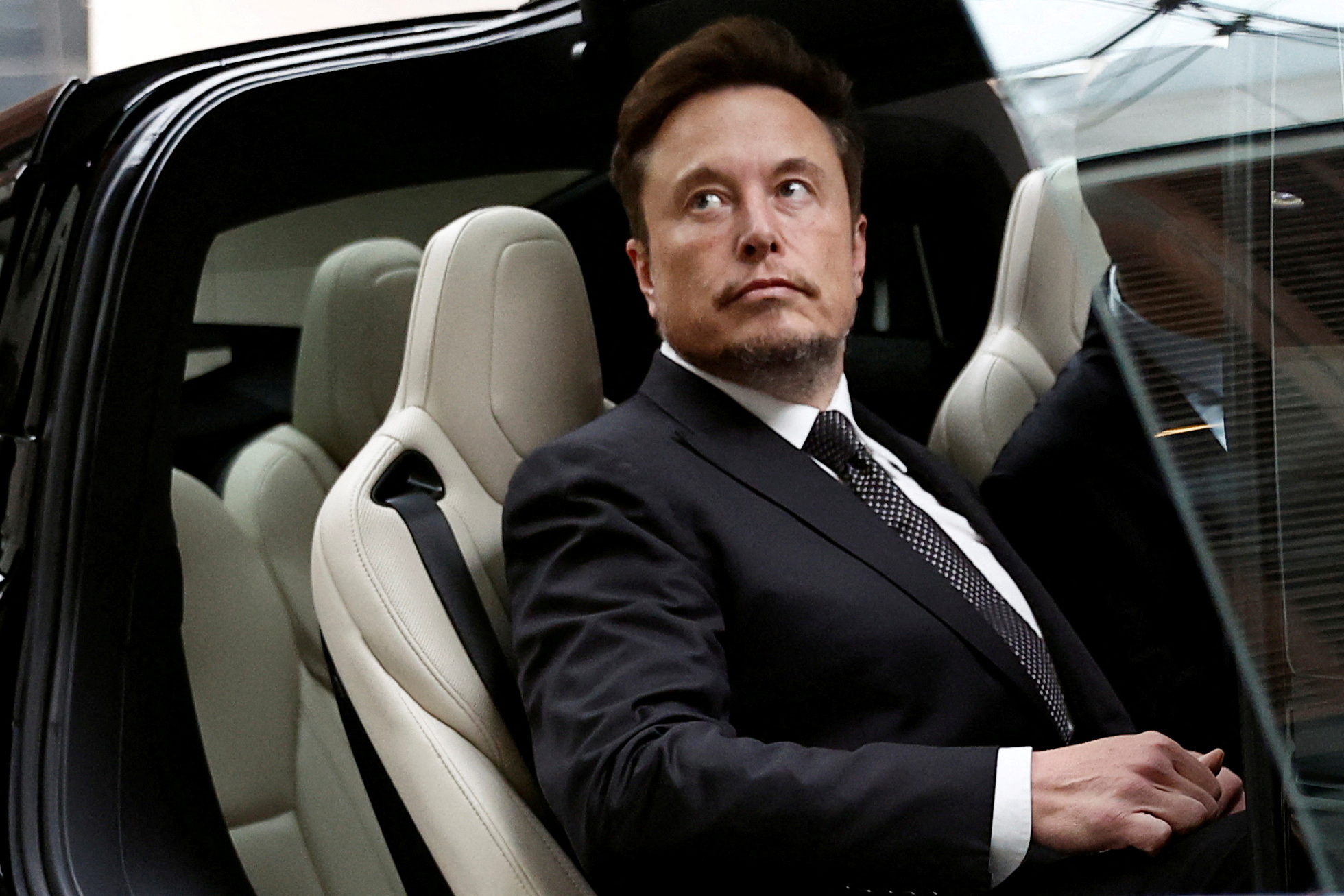 Elon Musk entrando em um carro da Tesla