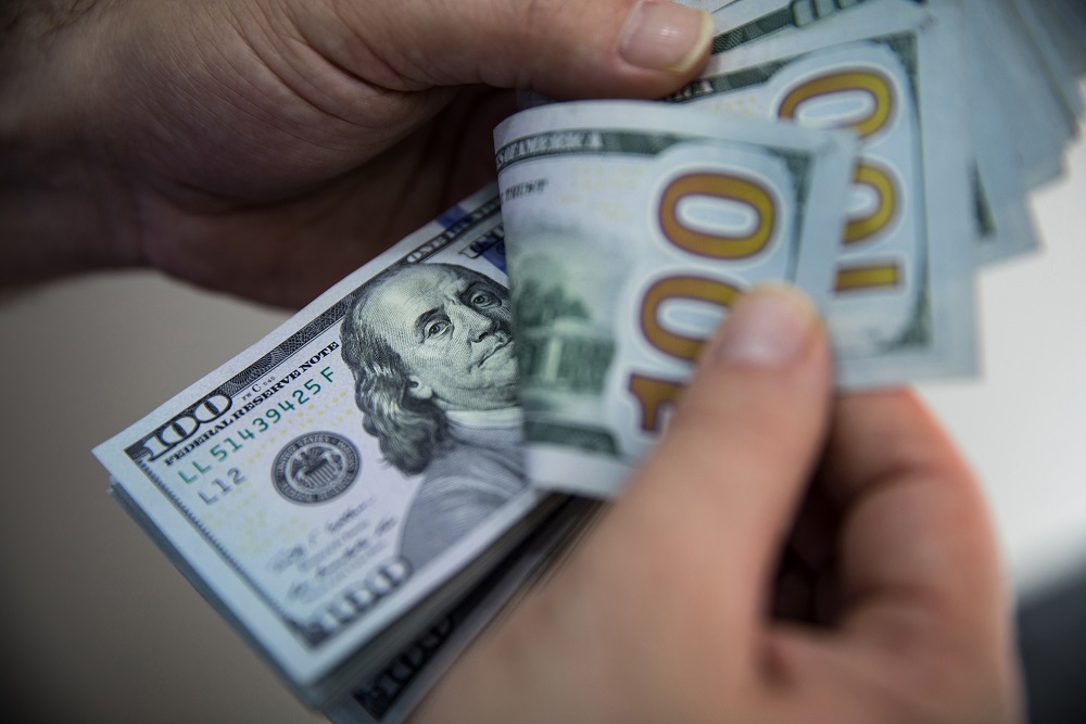 Um cliente manuseia 100 cédulas de 100 dólares americanos e 50 cédulas de euro em um escritório de câmbio no bairro de Beyoglu, em Istambul, Turquia, na quinta-feira, 14 de maio de 2020 (Kerem Uzel/Bloomberg)