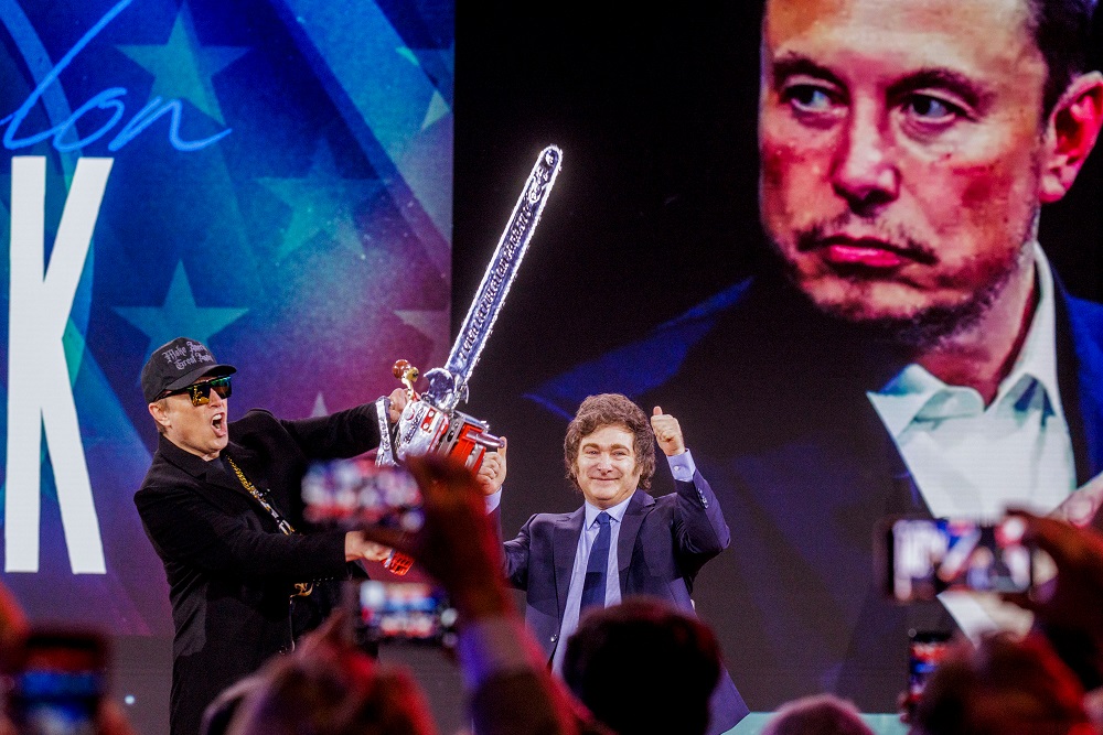 Elon Musk com uma motosserra na conferência