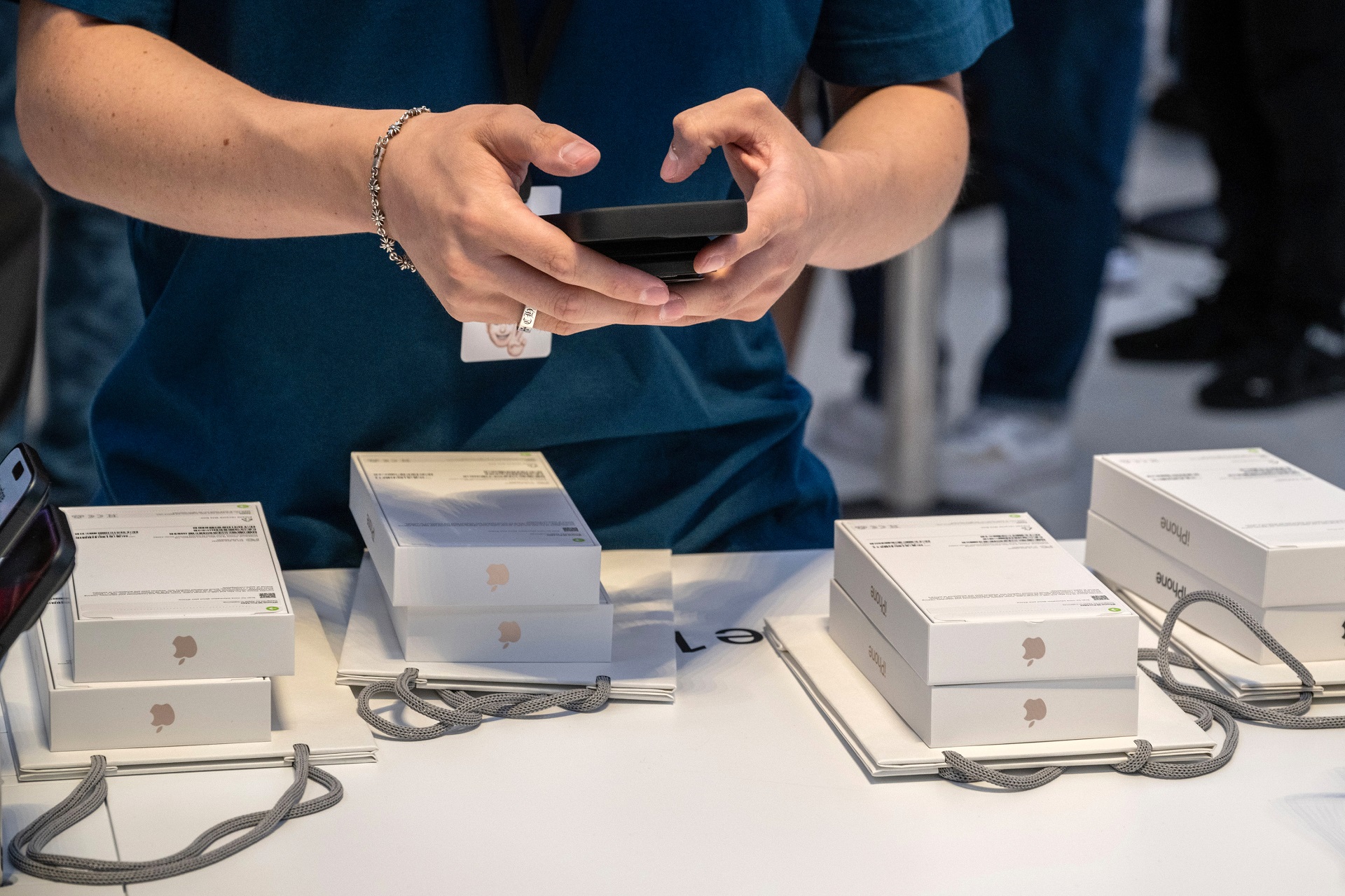 Funcionário vendendo iPhones na loja da Apple.