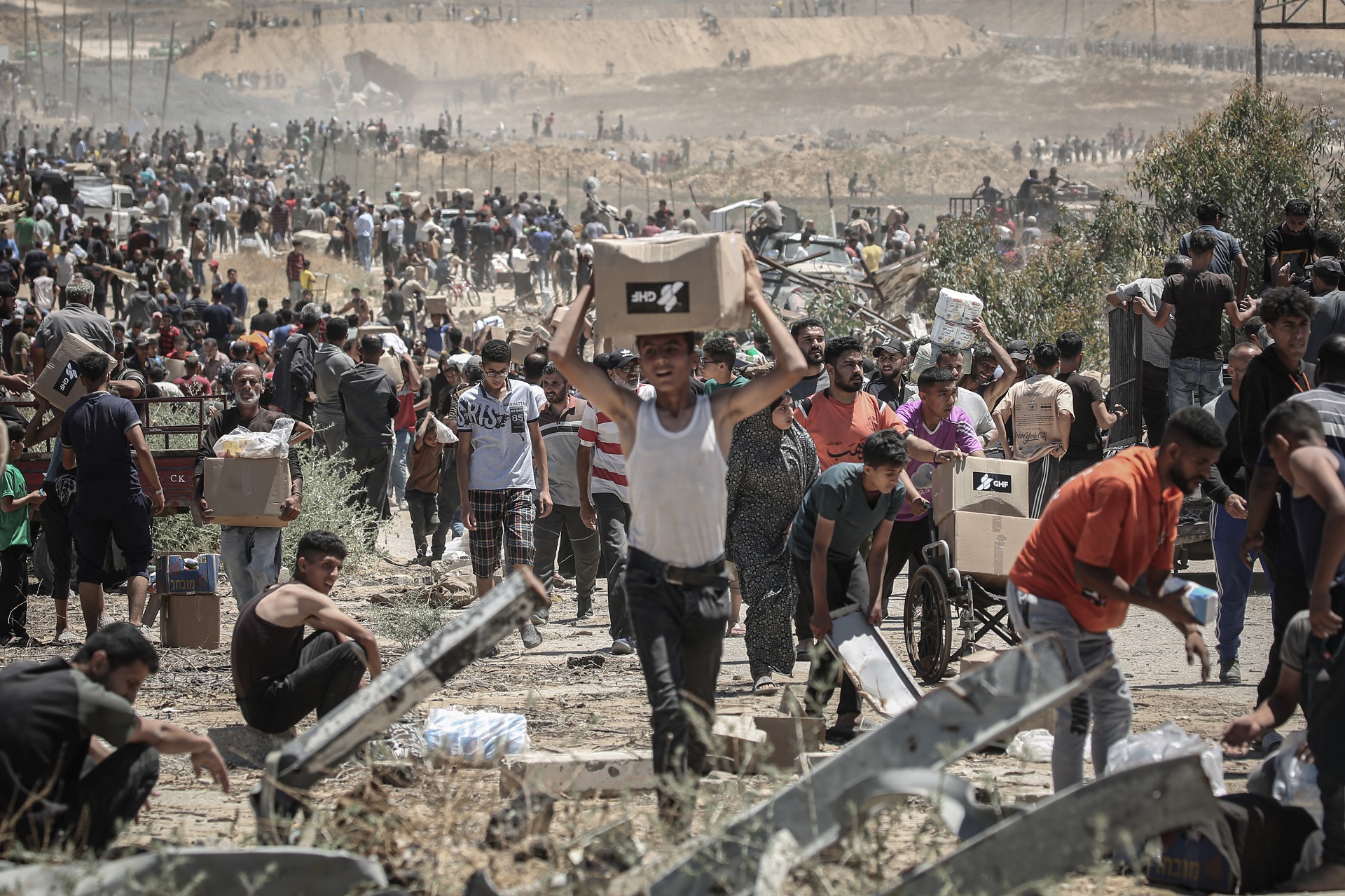 Caixas de ajuda humanitária sendo transportadas por palestinos.